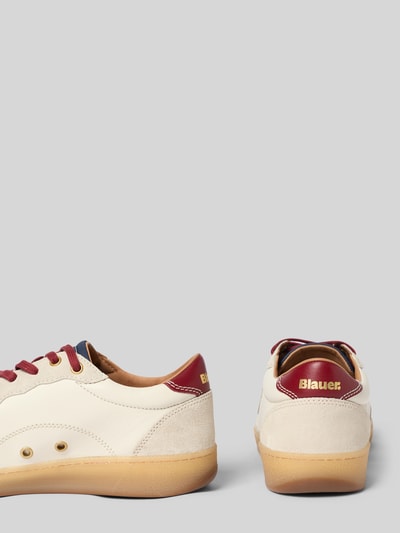 Produktfoto, Sneaker mit Label-Patches Modell 'Murray' von Blauer USA mit abgerundeter Form, strukturierter Sohle, roten Details, beige-cremefarbenes Obermaterial und Logo-Print, Schafthöhe 7 cm, Absatzhöhe 3 cm, Schaftweite 8 cm.
