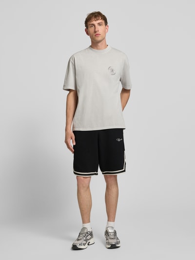 Männermodel trägt Shorts mit Strukturmuster und Label-Stitching von PEGADOR aus Reiner Baumwolle, Regular-Fit, elastischer Bund, Eingrifftaschen, farblich kontrastierende Details, Ganzkörperansicht von vorne.