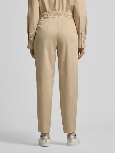 Vrouwenmodel draagt Straight Fit Stoffhose mit Tunnelzug van Marc Cain in beige, elastische katoenmix, geplooide details, deeltjes elastische tailleband, productinformatie, volledige lichaamsaanzicht achteraan.