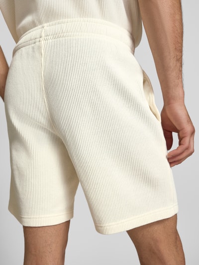 Männermodel trägt Shorts mit Strukturmuster und elastischem Bund von CHAMPION, Baumwoll-Mix, Regular Fit, Ganzkörperansicht Rückansicht.