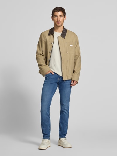 Männermodel trägt Regular Fit Jeans im 5-Pocket-Design Modell 'Lyon' von Pierre Cardin, blau, glatte Struktur, Ganzkörperansicht von vorne. Elastischer Baumwoll-Mix mit Lyocell-Anteil, Knopf- und Reißverschluss, Bundweite 41 cm, Innenbeinlänge 79 cm.