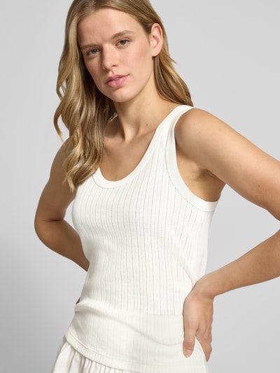 Frauenmodel trägt Regular-Fit Tanktop aus reiner Baumwolle von Marc O'Polo Denim in Weiß mit feiner Rippenstruktur, Nahaufnahme Oberkörper.