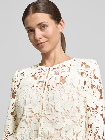 Kobiece modelka nosi Regular Fit Jacke aus floraler Spitze od Christian Berg Cocktail, kremowa koronka, okrągły dekolt, listwa guzikowa, długość tyłu w rozmiarze 36: 47 cm, zbliżenie górnej części ciała.