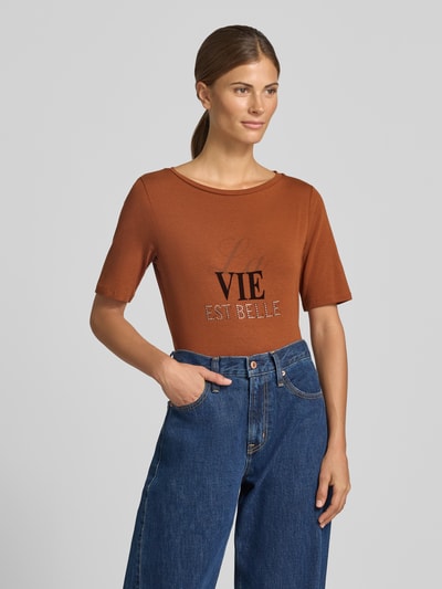 Vrouwenmodel draagt t-shirt met strass-steentjes van MORE & MORE in roestbruin, katoenmix met stretch, getailleerd, ronde hals, ruglengte maat 36: 57 cm, Nahaufnahme Oberkörper