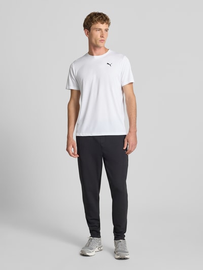 Männermodel trägt weißes Regular Fit Sport-T-Shirt mit Logo-Print Modell 'TAD Essential' von PUMA, Herren Sport-T-Shirt, Ganzkörperansicht von vorne.