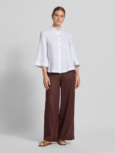 Frauenmodel trägt Relaxed Fit Leinenbluse mit 3/4-Arm von Christian Berg Woman in Weiß, Hemdblusenkragen, Knopfleiste, reine Leinen, Ganzkörperansicht von vorne.