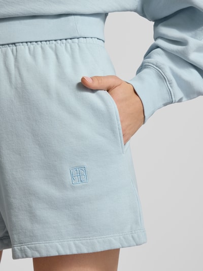 Frauenmodel trägt Regular Fit Shorts mit Logo-Stitching von Anine Bing aus reiner Baumwolle in Hellblau mit elastischem Bund und Eingrifftaschen, Nahaufnahme Hüfte.