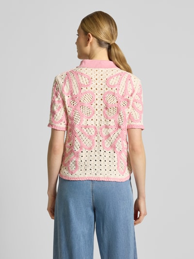 Frauenmodel trägt Strickjacke mit 1/2-Arm Modell 'GAVRILI' von SUNCOO PARIS, Gerader-Schnitt, Umlegekragen, Knopfleiste, creme mit rosa Muster, strukturierte Textur, Rückenlänge 48 cm, Ärmellänge 23 cm, Ganzkörperansicht Rückansicht.