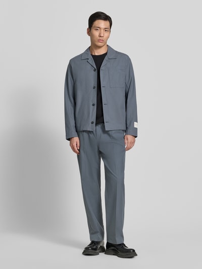 Männermodel trägt Straight Fit Anzughose aus Baumwoll-Lyocell-Mix Modell 'TURBULENCE' von CK Calvin Klein in Optik: Unifarben, Twill, mit Bundfalte, Gürtelschlaufen, Gürtel, Eingrifftasche und Gesäßtaschen; Ganzkörperansicht von vorne.