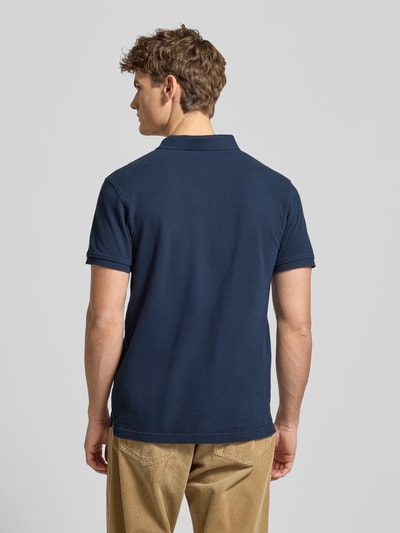 Männermodel trägt Poloshirt mit Label-Detail von Levi's®, dunkelblau, Baumwolle, Regular Fit, strukturierte Oberfläche, Ganzkörperansicht Rückansicht.