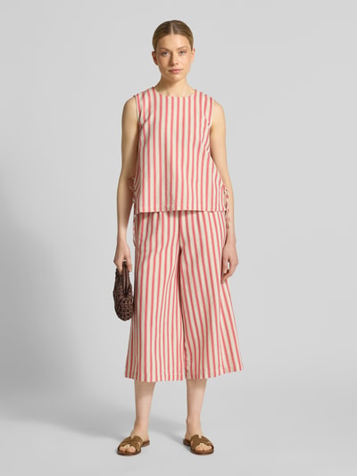 Frauenmodel trägt Stoffhose aus Viskose-Mix im Allover-Look Modell 'PRISILLA' von Vila, cremefarben mit roten Streifen, Leinen-Viskose-Anteil, Wide-Leg, elastischer Bund, Bundweite 35 cm, Innenbeinlänge 56 cm, Ganzkörperansicht von vorne.