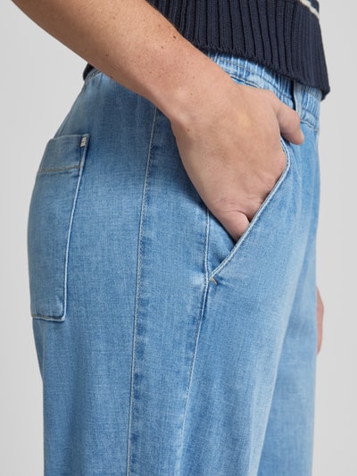 Frauenmodel trägt Wide Leg Jeans mit elastischem Bund von Brax im Used-Look, hellblauer Baumwoll-Mix mit Stretch, Nahaufnahme Hüfte.
