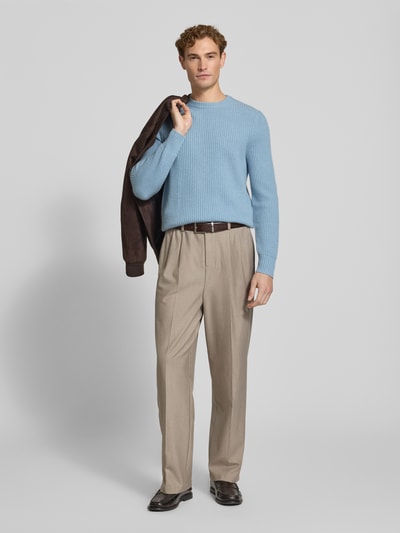 Männermodel trägt Strickpullover aus Kaschmir mit Rundhalsausschnitt von FTC Cashmere in Hellblau, Grobstrick, Ganzkörperansicht von vorne.