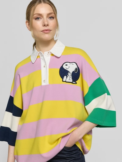 Kobiece model prezentuje koszulkę polo Oversized Poloshirt aus Viskose-Mix Modell 'JICE STRIPED EMBO' od Essentiel Antwerp, efekt: wielokolorowe szerokie paski, aplikacje z motywem, kołnierzyk polo, listwa guzikowa, rękaw o dł. 3/4, drobny splot, mieszanka wiskozy, widok na górną część ciała z przodu.