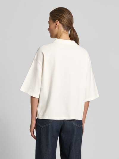 Frauenmodel trägt Cropped Poloshirt mit Ziersteinbesatz von Smith and Soul aus elastischem Baumwoll-Mix in Weiß, Rückenlänge 55 cm, Ganzkörperansicht Rückansicht.