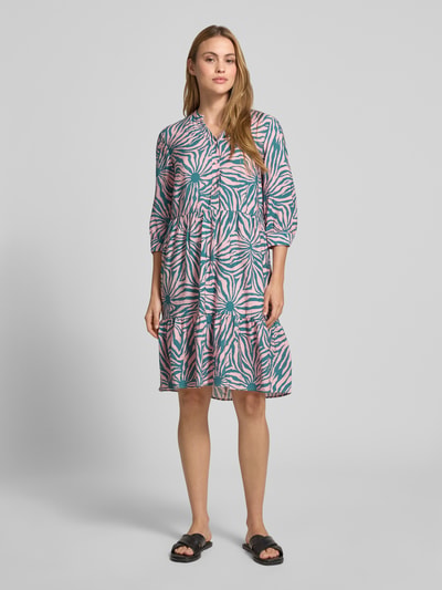 Frauenmodel trägt Relaxed Fit Midikleid aus Viskose-Mix mit Tunika-Ausschnitt und Knopfleiste von Christian Berg Woman, bunt gemustert, Halbarm, Rückenlänge 106 cm, Brustweite 48 cm, Ärmellänge 45 cm, Ganzkörperansicht von vorne.