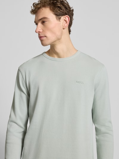 Männermodel trägt Regular Fit Langarmshirt aus Baumwoll-Mix Modell 'TEMPESTO' von BOSS Orange in unifarbenem Waffel-Piqué, Nahaufnahme Oberkörper.
