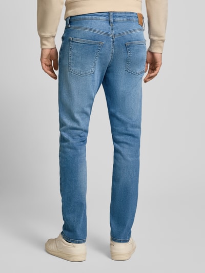 Männermodel trägt Slim Fit Jeans aus Baumwoll-Mix Modell 'SCANTON SLIM' von Tommy Jeans in Denim-Optik mit Label-Patch, Rückansicht.