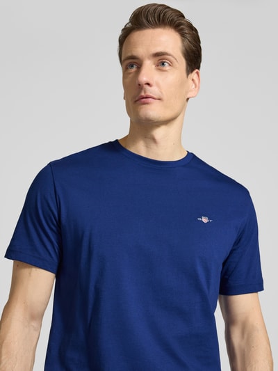 Männermodel trägt Regular Fit T-Shirt mit Logo-Stitching von Gant in Blau, reine Baumwolle, Rundhalsausschnitt, Nahaufnahme Oberkörper.