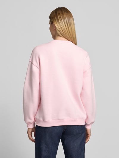 Frauenmodel trägt Sweatshirt mit Soul Stickerei von Smith and Soul in Unifarbe Rosa, Baumwollmix, gerippte Bündchen, Ganzkörperansicht Rückansicht.