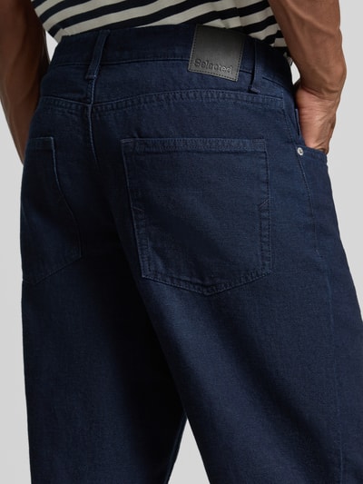 Männermodel trägt dunkelblaue Regular fit Tapered Jeans aus Baumwoll-Hanf-Mix Modell 'MAURO' von Selected, Herren Tapered Jeans, Nahaufnahme Rückansicht.
