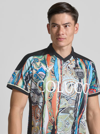 Männermodel trägt Slim Fit T-Shirt mit Label-Print von COLUCCI, farbenfrohe Muster, Polokragen, Ganzkörperansicht von vorne. Rückenlänge bei Größe M: 72 cm.