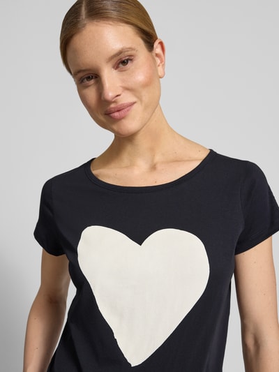 Vrouwenmodel draagt Regular Fit T-Shirt uit zuivere katoen van Marc O'Polo, effen ontwerp, motiefprint, ronde hals, korte mouw, jersey, close-up bovenlichaam.
