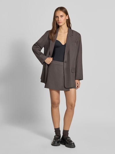 Frauenmodel trägt Regular Fit Skort mit Gürtelschlaufen Modell 'LINDA' von ONLY, grauer Damen Mini-Rock, glatte Textur, Ganzkörperansicht von vorne.
