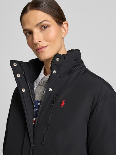 Frauenmodel trägt Regular Fit Mantel aus Baumwoll-Mix von Polo Ralph Lauren in Schwarz mit roten Akzenten, Nahaufnahme Oberkörper. Damen Mantel von Polo Ralph Lauren
