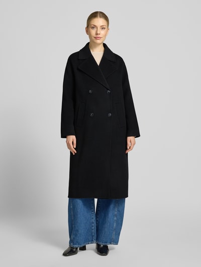 Kobiece model prezentuje Relaxed Fit Mantel aus reiner Wolle mit 2-Knopfleiste von Milano Italy, czarny, tkanina wełniana, klasyczny krój relaxed fit, kołnierz z klapami, dwurzędowe zapięcie na dwa guziki, kieszenie wpuszczane, długość tyłu w rozmiarze 36: 115 cm, szerokość ramion w rozmiarze 36: 45 cm, szerokość biustu w rozmiarze 36: 56 cm, długość rękawa w rozmiarze 36: 55 cm, zdjęcie całopostaciowe z przodu.