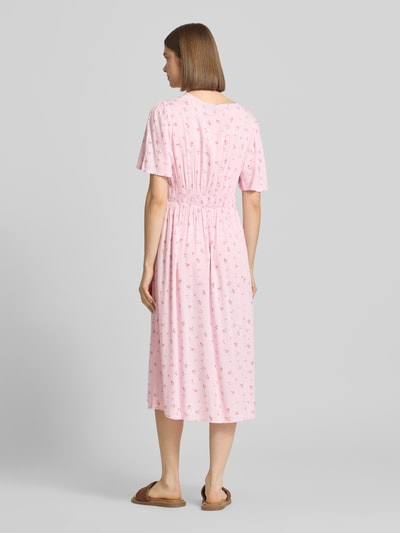 Frauenmodel trägt A-Linien Midikleid aus reiner Viskose Modell 'TALA' von Pieces mit Allover-Muster in zartem Rosa, Rückansicht.