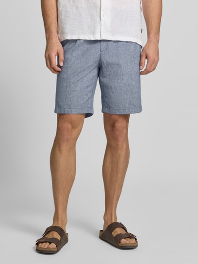 Männermodel trägt Bermudas mit französischen Eingrifftaschen Modell 'COLI' von Fynch-Hatton, Baumwoll-Mix mit Leinen-Anteil, Loose-Fit, elastischer Bund mit Kordelzug, mittleres Blau, Textur leicht meliert, Nahaufnahme Oberkörper bis Knie.