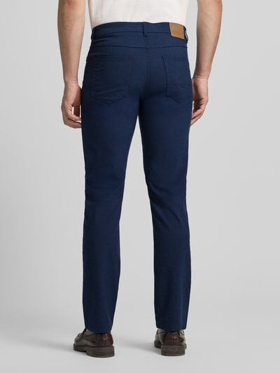 Männermodel trägt Chino mit 5-Pocket-Design von Christian Berg Men in Dunkelblau, gerader Schnitt, Material-Mix, Ganzkörperansicht Rückansicht.