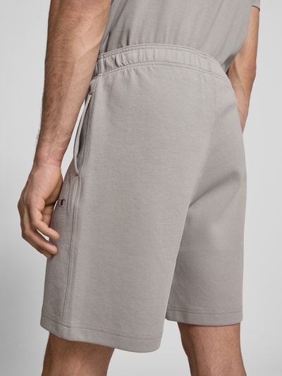 Männermodel trägt Shorts mit elastischem Bund und Label-Stitching von CHAMPION, Baumwoll-Mix, hellgrau, Regular Fit, Ganzkörperansicht Rückansicht.