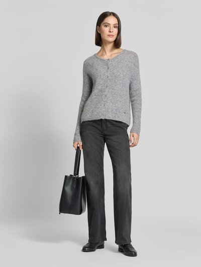 Frauenmodel trägt Regular Fit Strickjacke aus Woll-Alpaka-Mix Modell 'Almine' von MOS MOSH, meliertes Grau, Knopfleiste, Ganzkörperansicht von vorne.