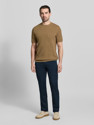 Męski model nosi Spodnie materiałowe Slim Fit Stoffhose mit Lyocell-Anteil Modell 'Cadiz' von BRAX, granatowe, 5 kieszeni, elastyczna mieszanka bawełny i lyocellu, zapięcie na guzik i zamek błyskawiczny, Szerokość w rozmiarze 32/32: 107 cm, Długość wewnętrzna nogawki: 81 cm, Ganzkörperansicht von vorne