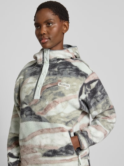 Vrouwenmodel draagt hoodie met label-patch model 'Helvetia' van Columbia, fleece met rechte fit, kap en drukknopen, zijzakken, Nahaufnahme bovenlichaam.