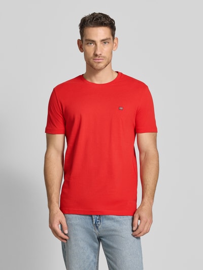 Männermodel trägt T-Shirt aus Baumwolle mit Rundhalsausschnitt von Christian Berg Men in Rot, Regular-Fit, Label-Detail, Ganzkörperansicht von vorne. Reine Baumwolle, Rückenlänge bei Größe M: 71 cm.