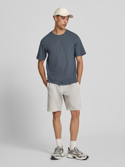 Męski model nosi Regular Fit T-Shirt mit Rundhalsausschnitt von Jack & Jones, bawełna, krój regular fit, okrągły dekolt, rękaw o dł. 1/2, długość tyłu w rozmiarze M: 70 cm, widok całej sylwetki z przodu