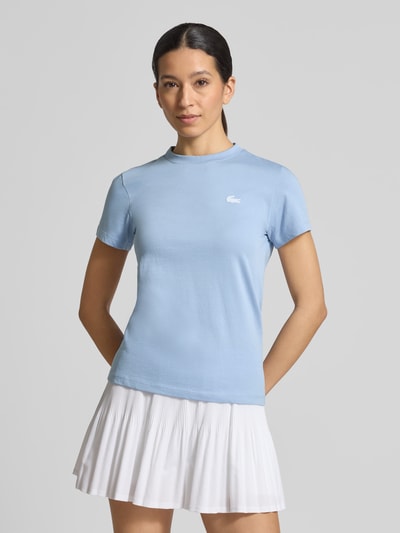 Frauenmodel trägt Slim Fit T-Shirt aus Baumwoll-Mix von Lacoste in Optik: Unifarben mit Logo-Patch, Rundhals-Ausschnitt, Ganzkörperansicht von vorne.