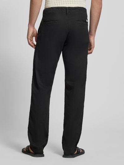 Männermodel trägt Relaxed Fit Hose aus Baumwoll-Leinen-Mix Modell 'KANE' von Jack & Jones, elastischer Bund, Schwarz, Ganzkörperansicht Rückansicht.