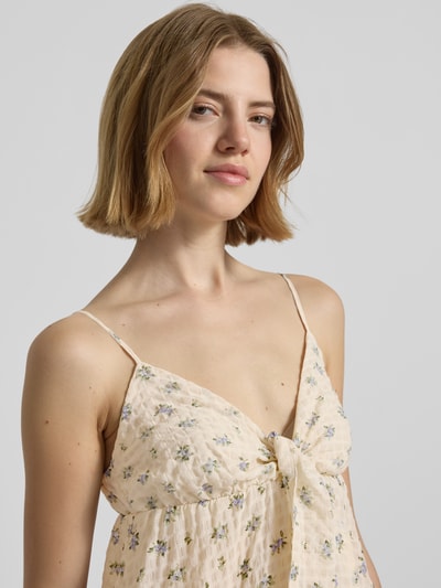 Frauenmodel trägt Minikleid mit Volantsaum und Spaghettiträgern von REVIEW, Seersucker mit floraler Allover-Print, Nahaufnahme Oberkörper.