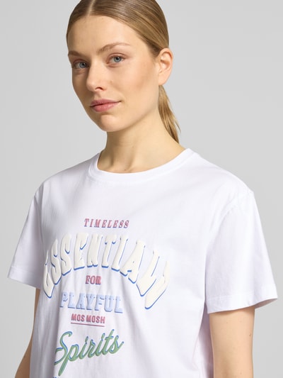 Frauenmodel trägt T-Shirt mit Rundhalsausschnitt Modell 'Raft' von MOS MOSH in Weiß, Label-Print, reine Baumwolle, Nahaufnahme Oberkörper.