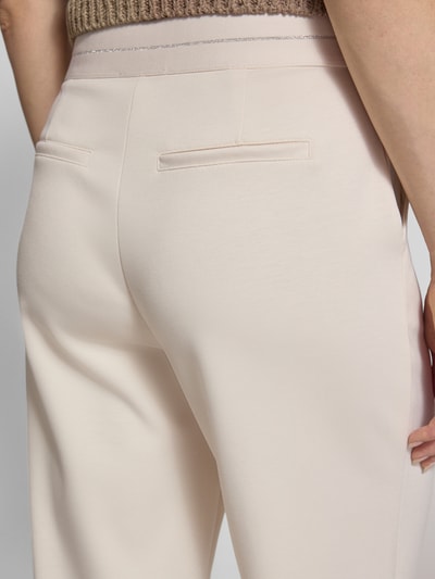 Frauenmodel trägt Wide Fit Stoffhose mit Viskose-Anteil Modell 'Lurex' von monari in Beige, Elastischer-Material-Mix, Gesäßtaschen, Eingrifftaschen, Detailaufnahme Rückansicht.