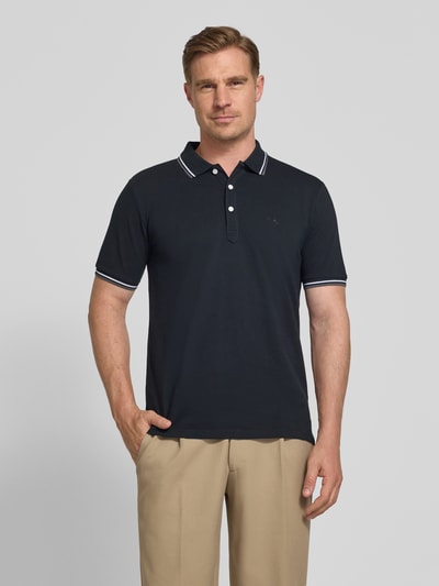 Mężczyzna model nosi Relaxed Fit Poloshirt mit Kontraststreifen von Lindbergh, bawełna, krój relaxed fit, paski w kontrastowym kolorze, listwa guzikowa, wyhaftowane logo, długość tyłu w rozmiarze M: 67 cm, widok całej sylwetki z przodu