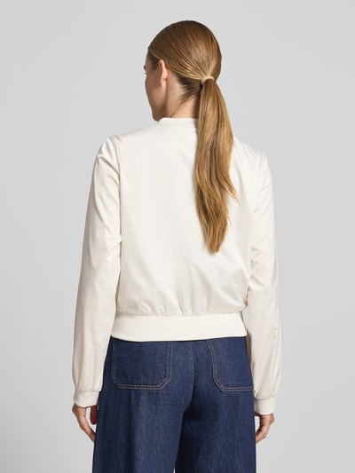 Frauenmodel trägt Jacke mit Rundhalsausschnitt und Reißverschlusstaschen von monari in Creme, Regular-Fit, Rückenlänge 52 cm, Schulterbreite 46 cm, Brustweite 53 cm, Ärmellänge 57 cm, Ganzkörperansicht Rückansicht.
