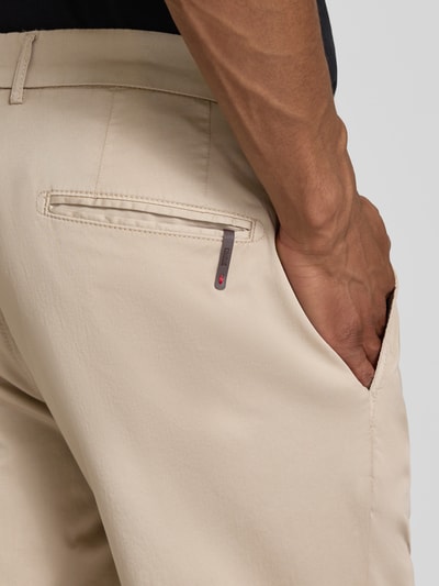 Mężczyznamodel nosi Anzughose mit Biesen und französischen Eingrifftaschen od CINQUE, beżowy bawełniany materiał, krój slim fit; zbliżenie tył. Szerokość w rozmiarze 50: 48 cm, długość nogawki 76 cm.
