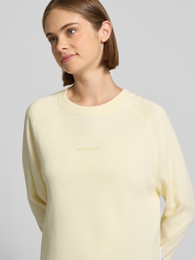 Frauenmodel trägt Regular Fit Sweatshirt aus reiner Baumwolle von Marc O'Polo DENIM in hellem Gelb, glatte Textur, Nahaufnahme Oberkörper.