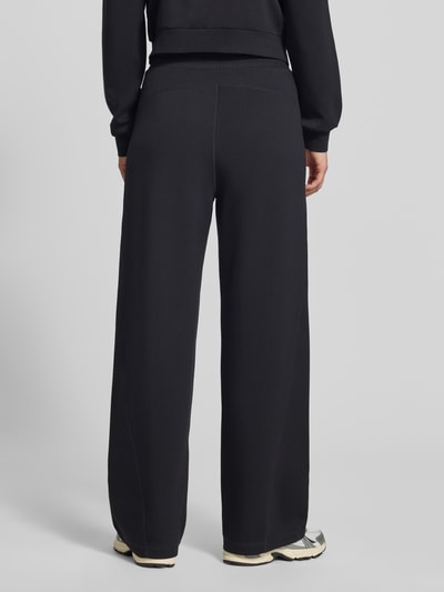 Vrouwenmodel draagt Wide Fit broek uit viscosemix met elastische band van Liu Jo, steekzakken, zwart, binnenbeenlengte 79 cm, Ganzkörperansicht Rückansicht.