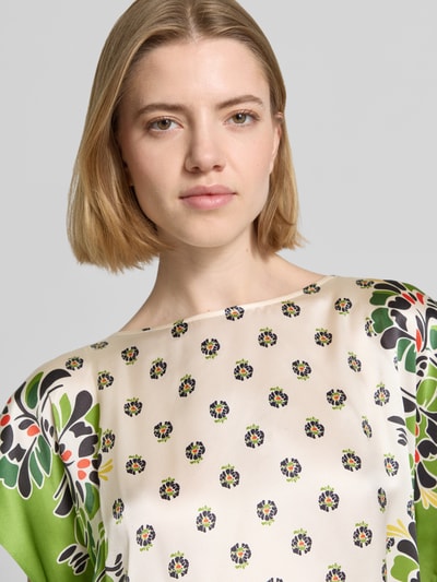 Frauenmodel trägt Bluse mit U-Boot-Ausschnitt von Marc Cain aus Micromodal-Mix mit Stretch-Anteil, gemusterter Stoff, Nahaufnahme Oberkörper.